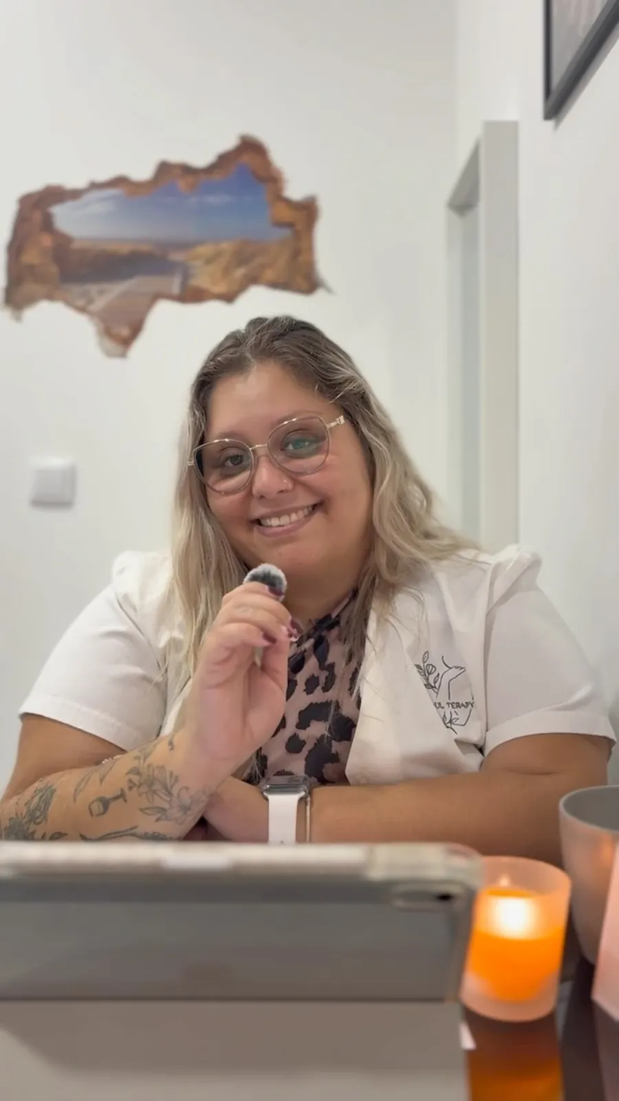 A Andreia, de bata branca com o logótipo da AS Soul Terapy, sentada na receção do espaço