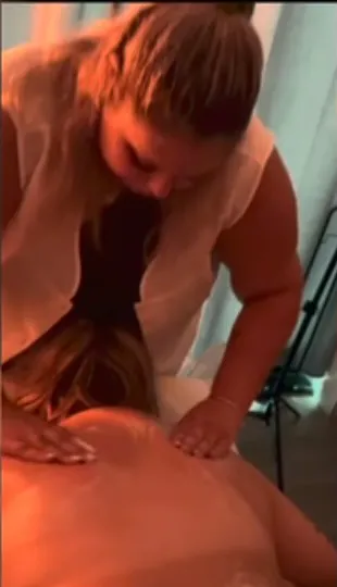 A Andreia a fazer uma massagem às costas, com a luz quente da sala